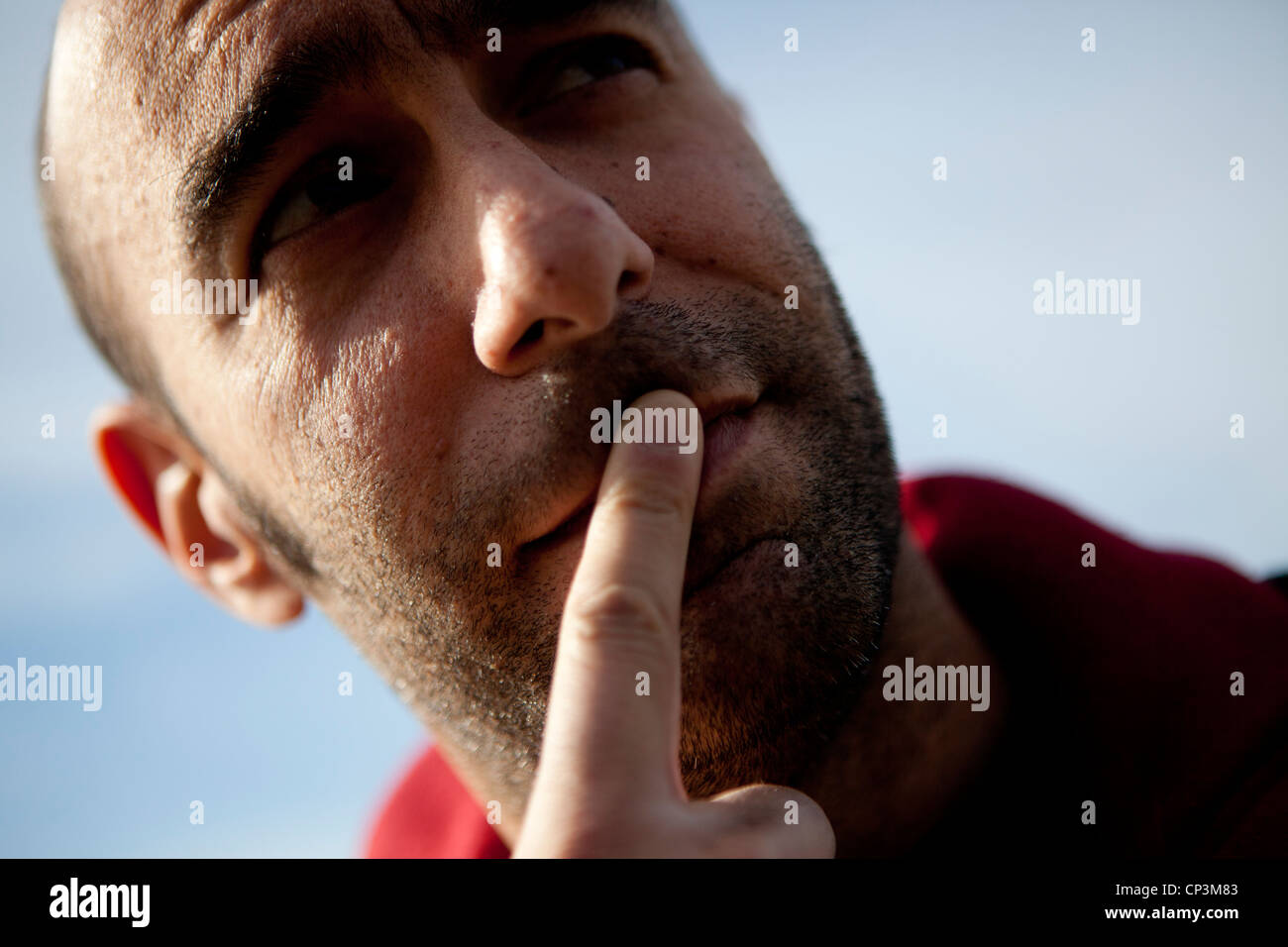 Cerca del hombre con el dedo en los labios Foto de stock