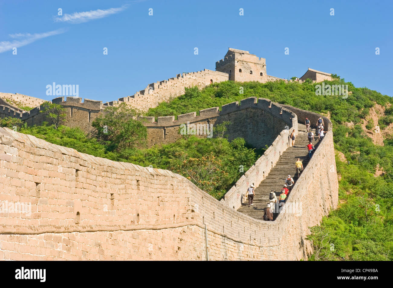 Un grupo de turistas subir escalones en el tour caminando Jinshanling sección de la Gran Muralla de China. Foto de stock
