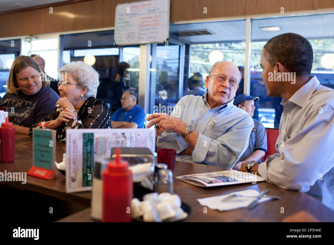 El presidente Barack Obama habla con un patrono a Reid's House Restaurant en Reidsville, N.C., durante una parada para almorzar en el American Foto de stock