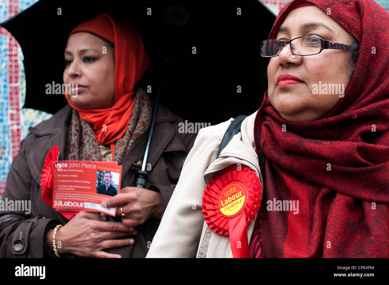 Puede3rd 2012 elección de Londres. Columbia Road centro de votación. Dos mujeres asiáticas de comunidad de Bangladesh con rosetas de trabajo Foto de stock