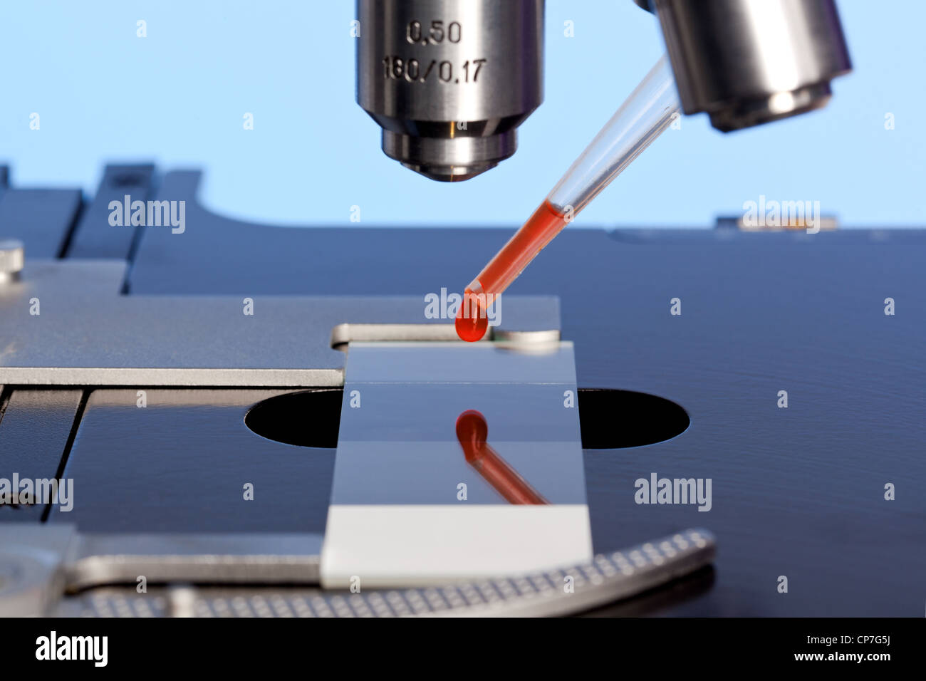 Foto de un microscopio de laboratorio con una muestra de sangre en un portaobjetos de vidrio. Foto de stock