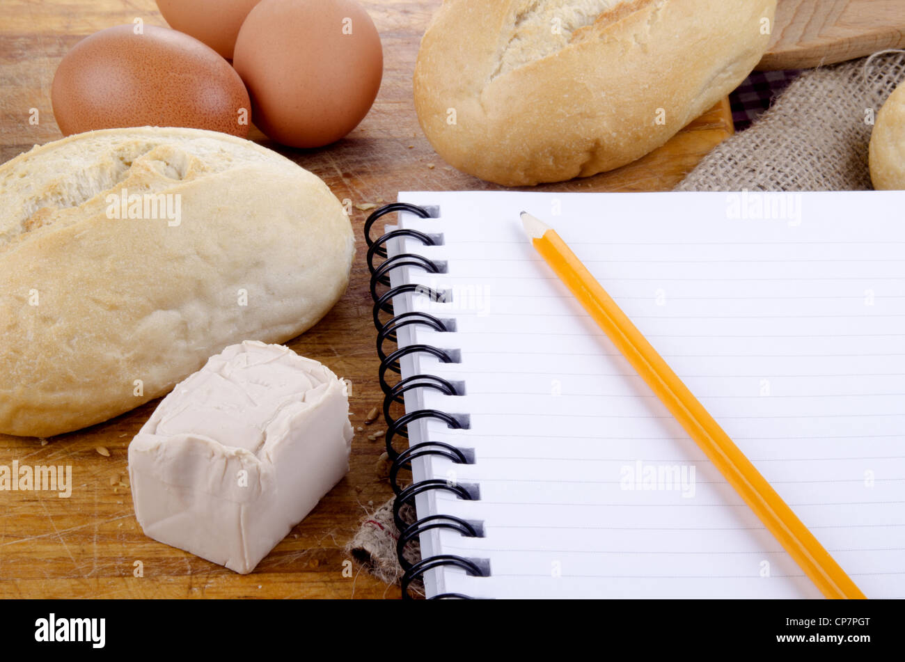 Rollo francés y un cuaderno de notas con lápiz Foto de stock