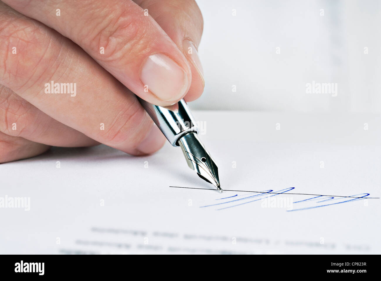 Cerca de una mano con la pluma de firmar un documento. Foto de stock