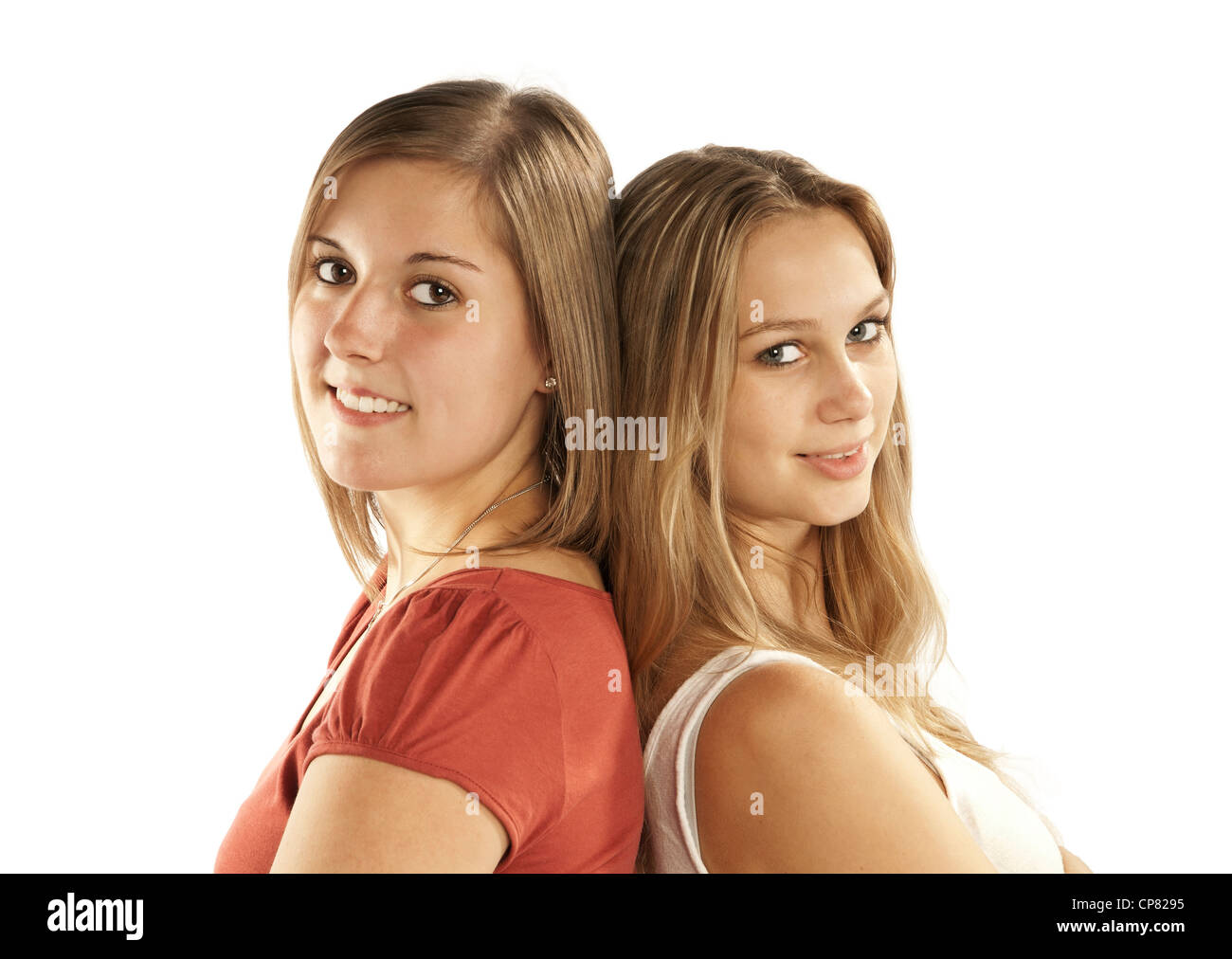 Dos bonitas mujeres jóvenes recostado de espaldas unos a otros. Foto de stock