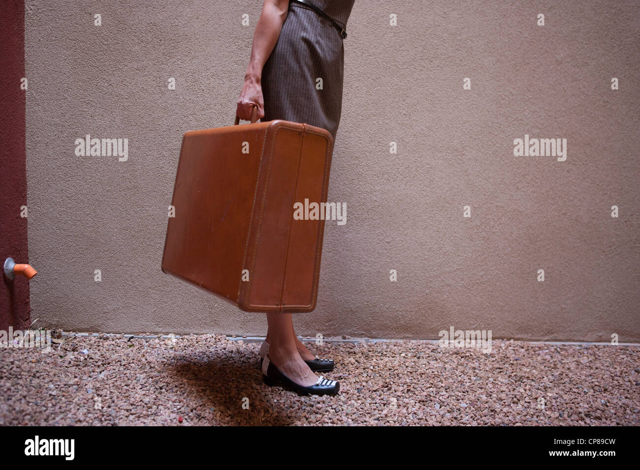 Mujer que llevaba una maleta vintage Fotografía de stock - Alamy