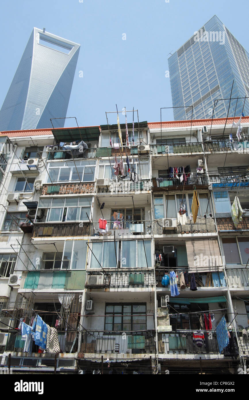Contraste entre el viejo edificio de apartamentos con modernos rascacielos en la parte trasera en el distrito financiero de Lujiazui en Shanghai China Foto de stock