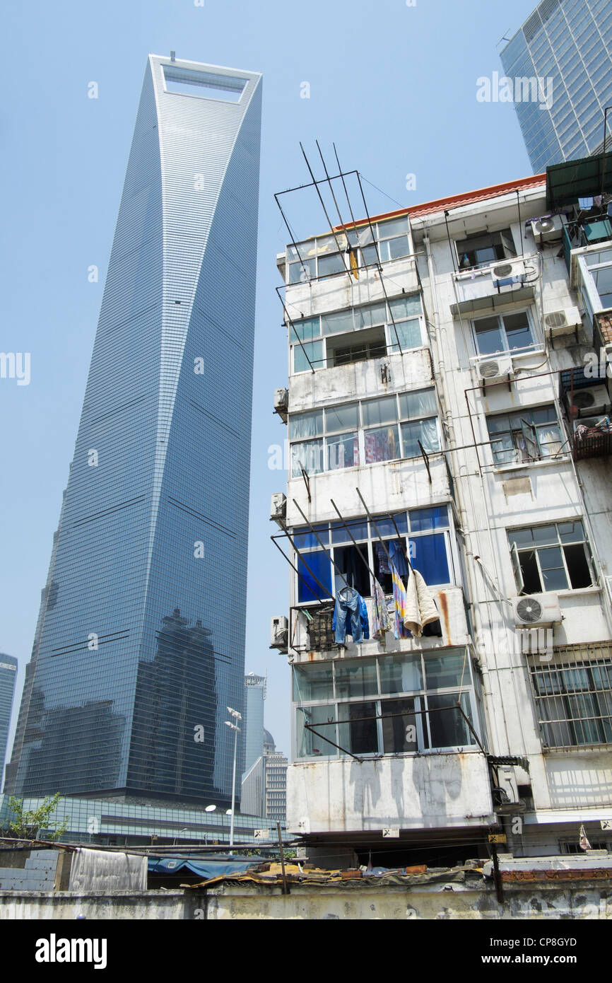 Contraste entre el viejo edificio de apartamentos con modernos rascacielos en la parte trasera en el distrito financiero de Lujiazui en Shanghai China Foto de stock