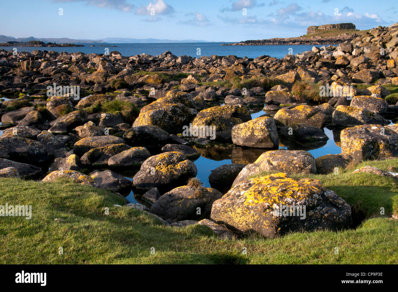 Un paisaje de puerto mor Isle of muck con interesantes rocas en primer plano las pequeñas islas fuera de la costa oeste de Escocia Foto de stock