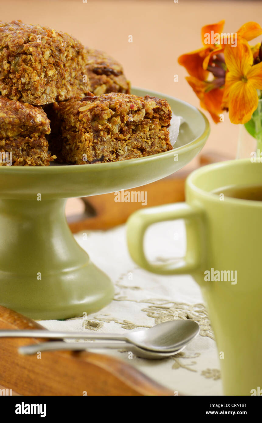 Granola casera saludable plazas con tazas de té en bandeja de madera Foto de stock