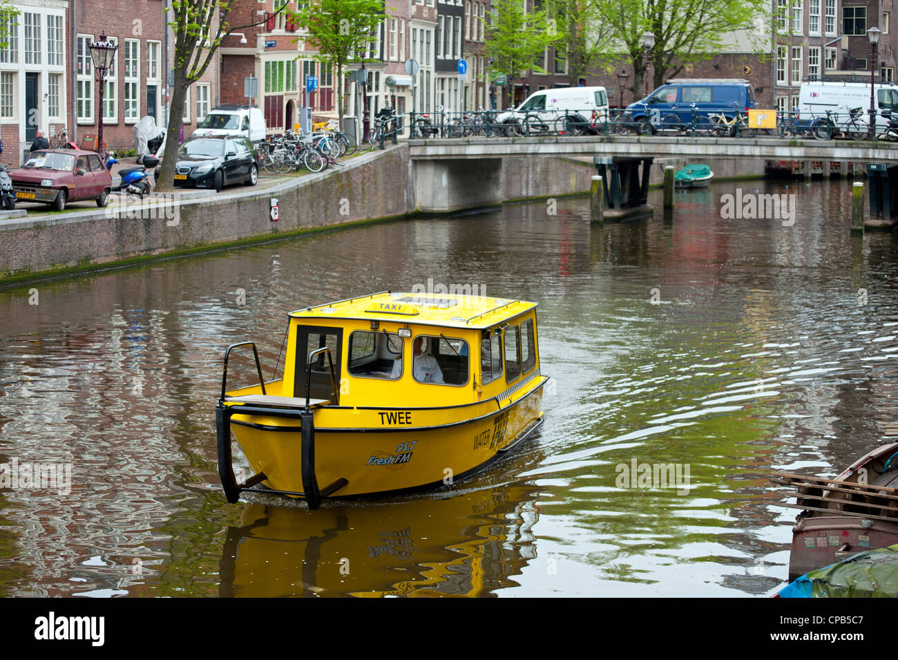 AMSTERDAM, PAÍSES BAJOS - MAYO 08, 2012: Pequeño taxi acuático en el Canal Foto de stock