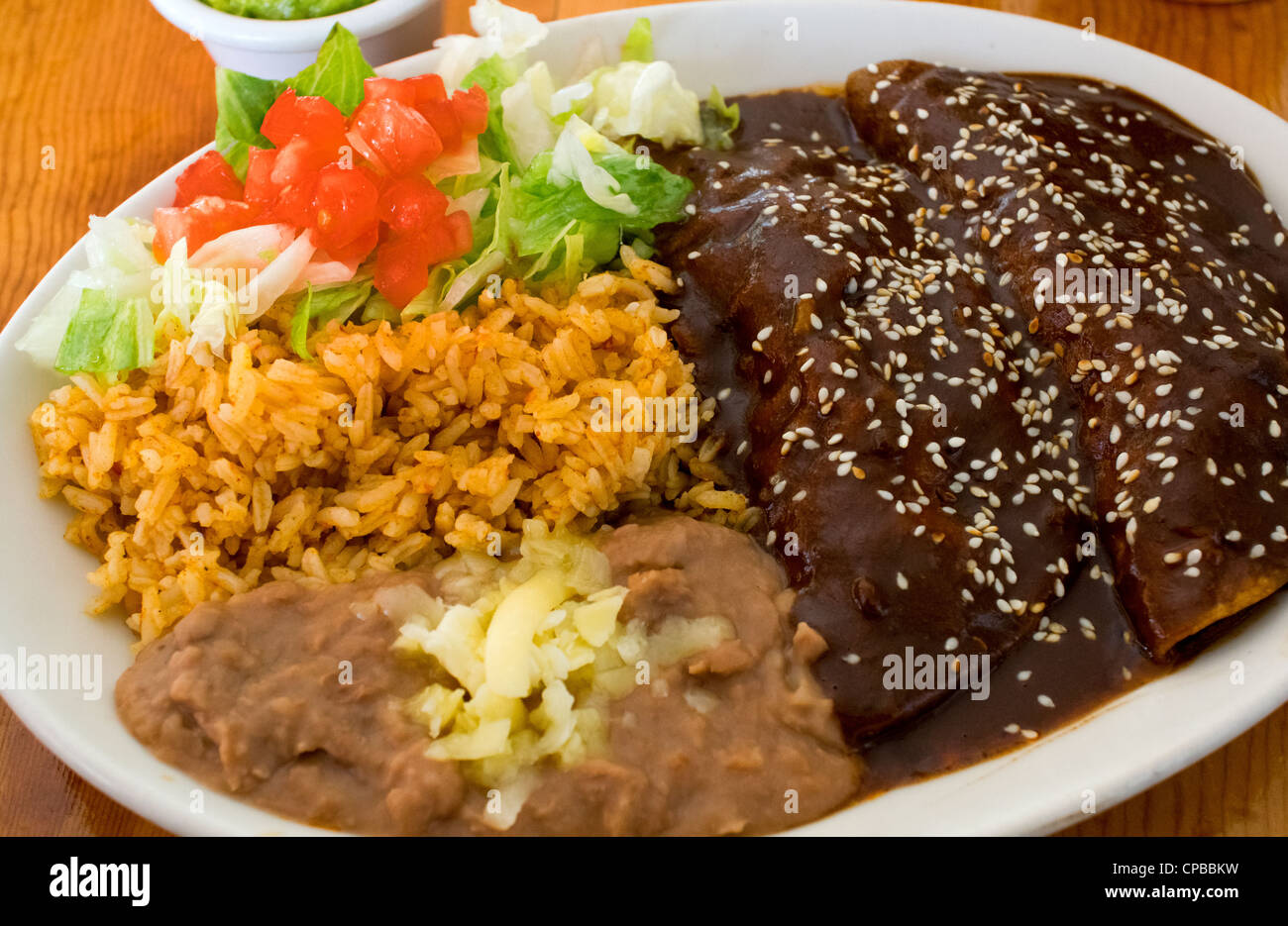 Enchiladas de mole con arroz y frijoles con queso y ensaladas