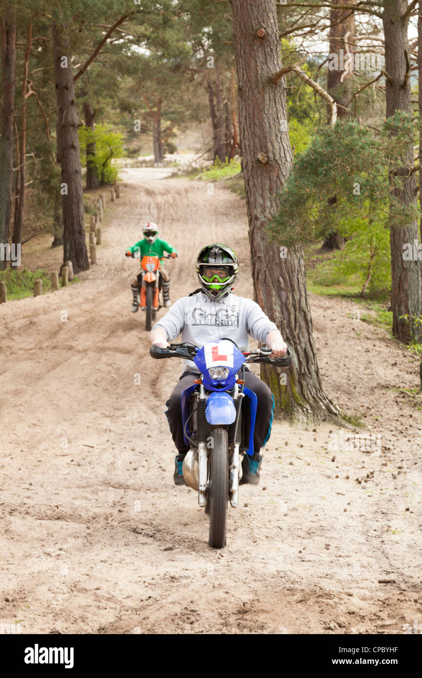 Jóvenes motociclistas alumno off road en pista forestal Foto de stock