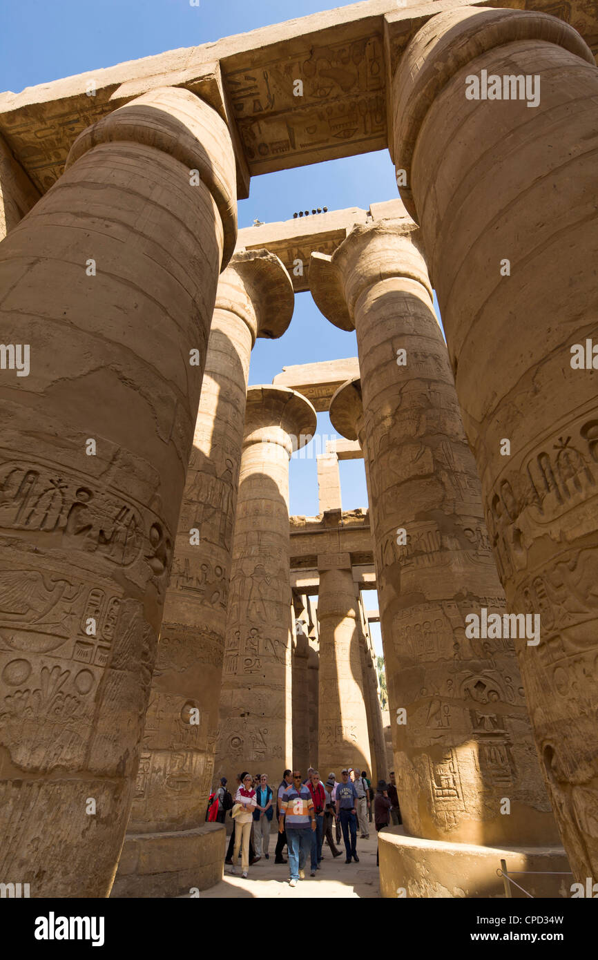 Los turistas se ven contrarrestadas por las imponentes columnas de la gran sala hipóstila salen del templo de Karnak de Amun, Tebas, Egipto, África Foto de stock