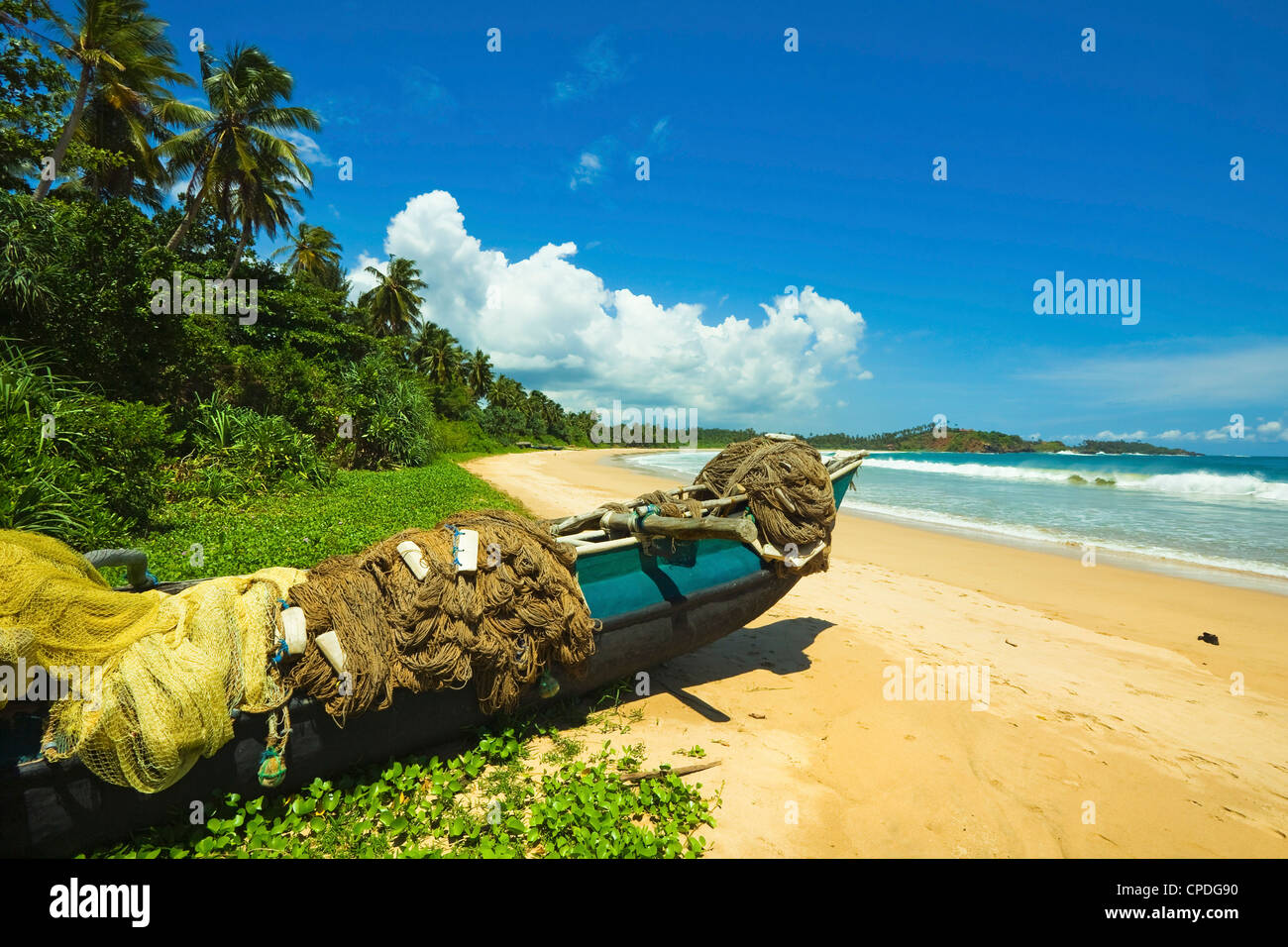 Outrigger botes de pesca y redes en este tranquilo refugio costa sur playa, Talalla, cerca de Matara, la provincia meridional de Sri Lanka Foto de stock