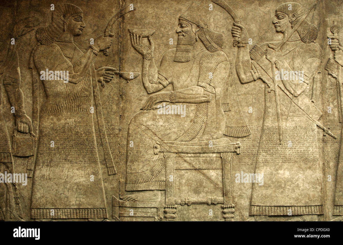 Rey Ashurnasirpal II sentado en el trono entre dos asistentes. 865-860 A.C. De Nimrud. Palacio Noroeste. Foto de stock