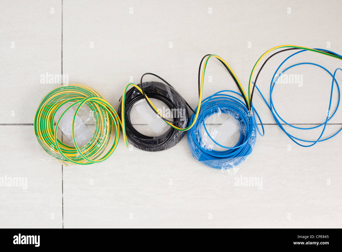 Bobina de cable eléctrico en tres colores: negro azul y verde Amarillo tierra Foto de stock