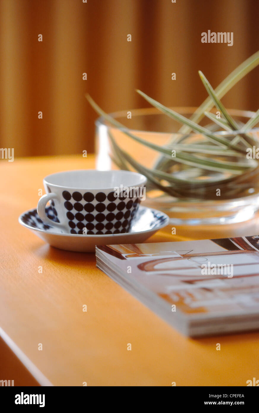 Vaso, Plato, tazón de vidrio y una revista en la mesa Foto de stock