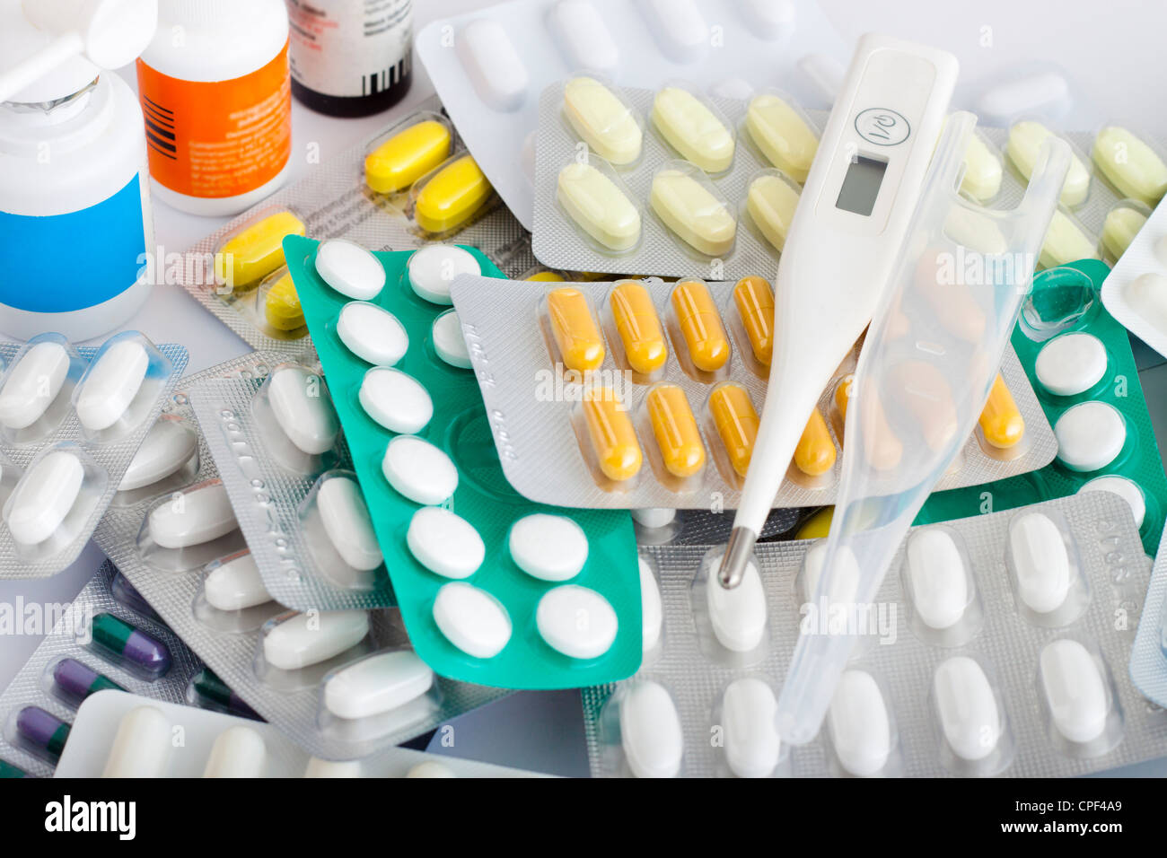 Montón de suministros médicos, pastillas, tabletas, cápsulas y termómetro. Foto de stock