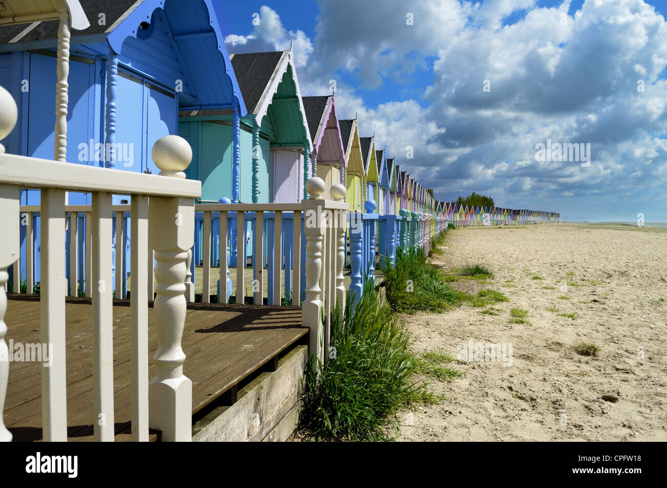 Una línea de coloridas casetas de playa por el océano Foto de stock