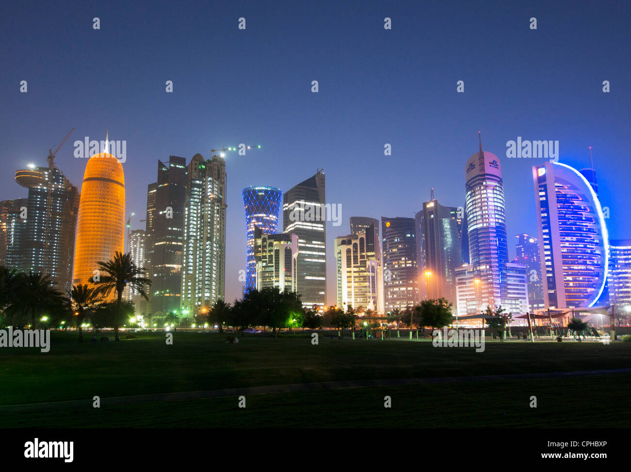 Por la noche la vista de los modernos rascacielos en la noche en la calle Corniche en el nuevo distrito de negocios de Doha en Qatar Foto de stock