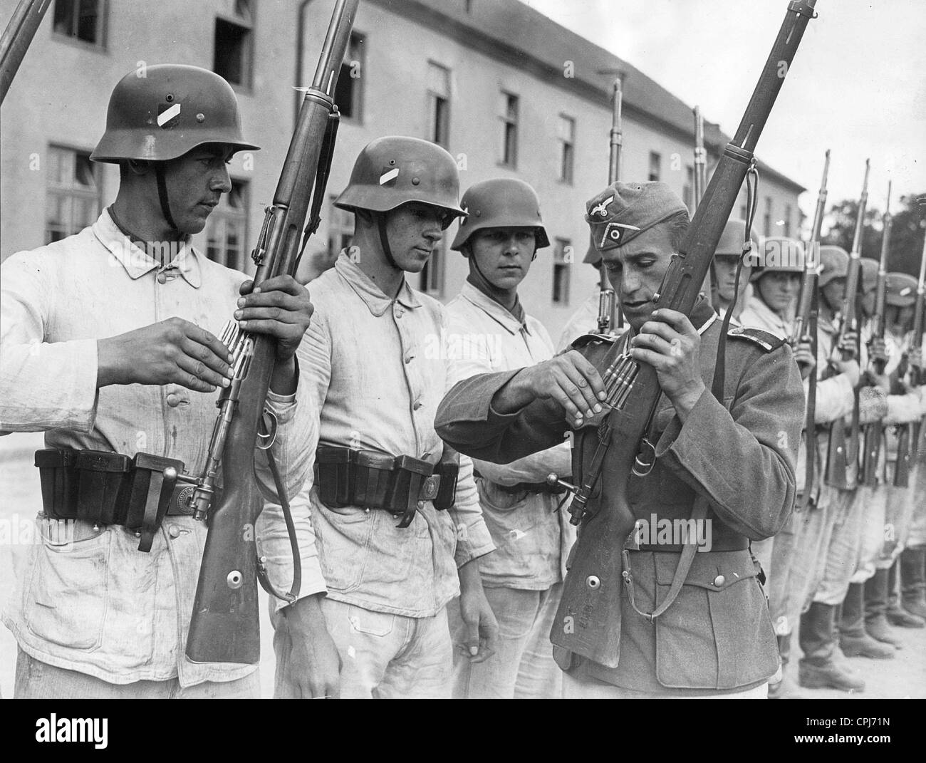 Suboficial reclutas muestra cómo cargar una carabina, 1940 Foto de stock