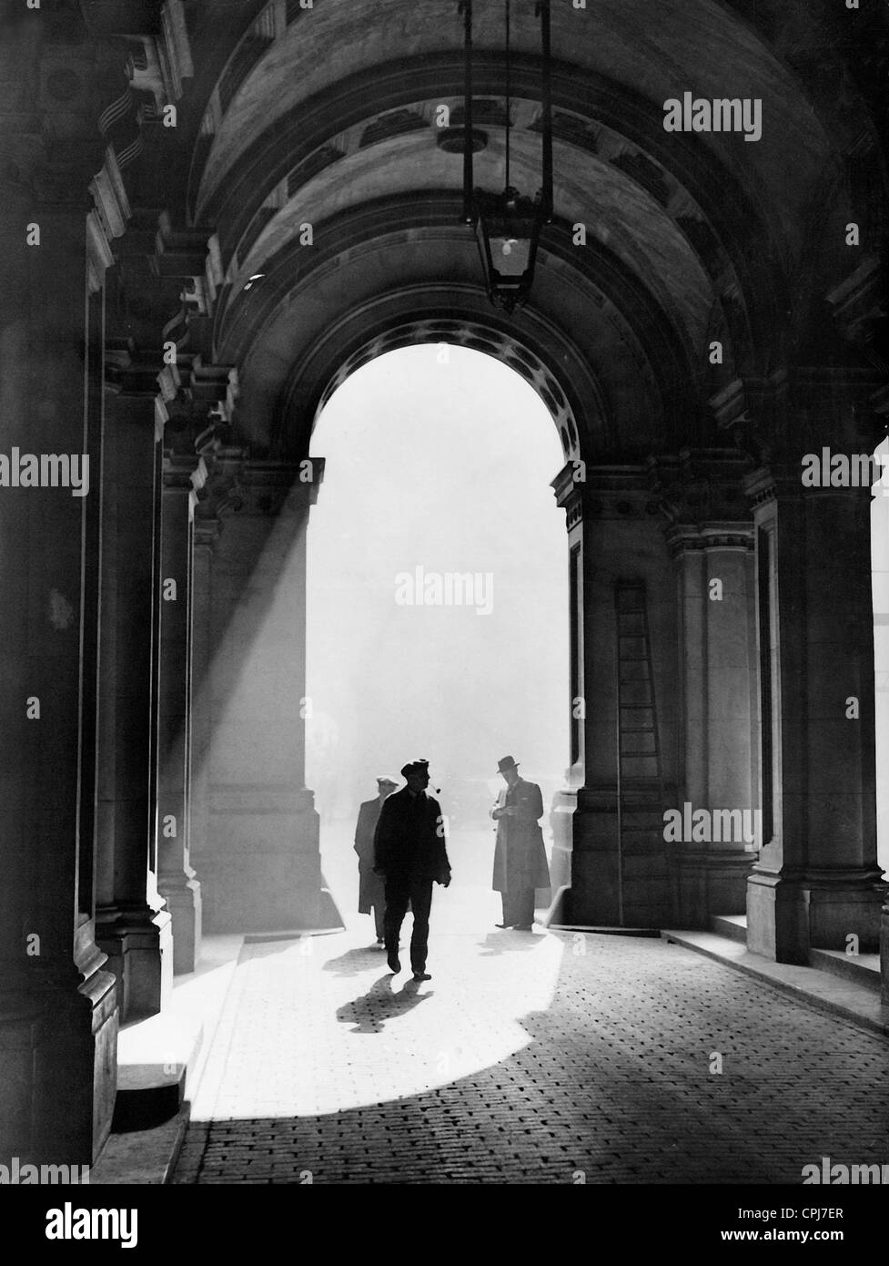 Los hombres pasan a través del arco del Ministerio de Relaciones Exteriores británico en Londres, 1938 Foto de stock