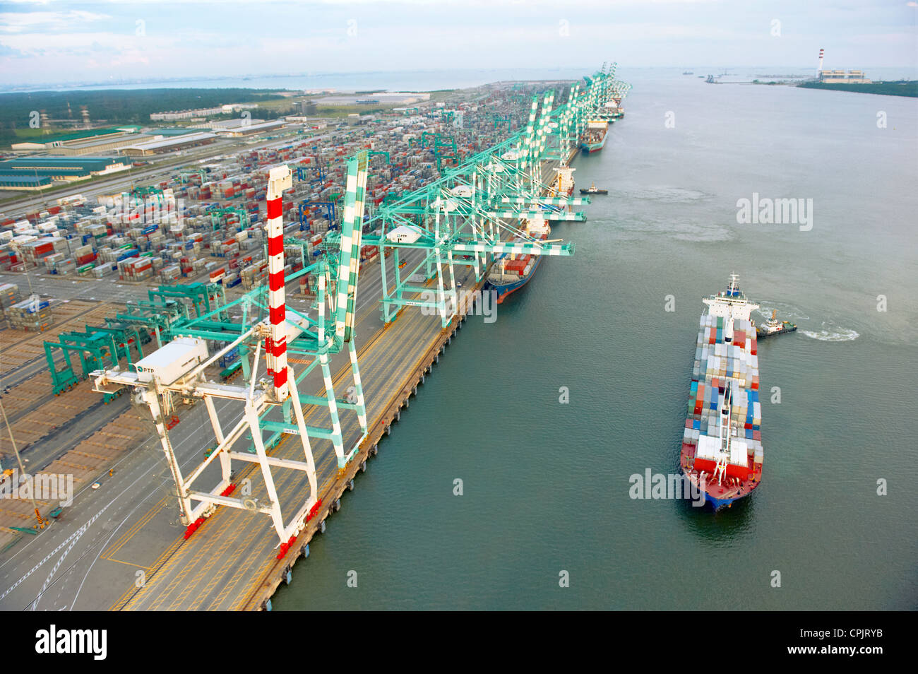 Un buque que pasaba por una terminal de contenedores del puerto de embarque en Johor, Malasia. Foto de stock