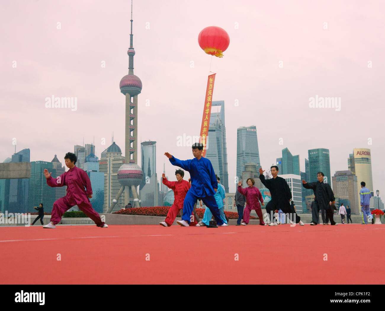 Taichi personas jugando en la mañana en el Bund, en el fondo el horizonte de Pudong, Shanghai, China Foto de stock