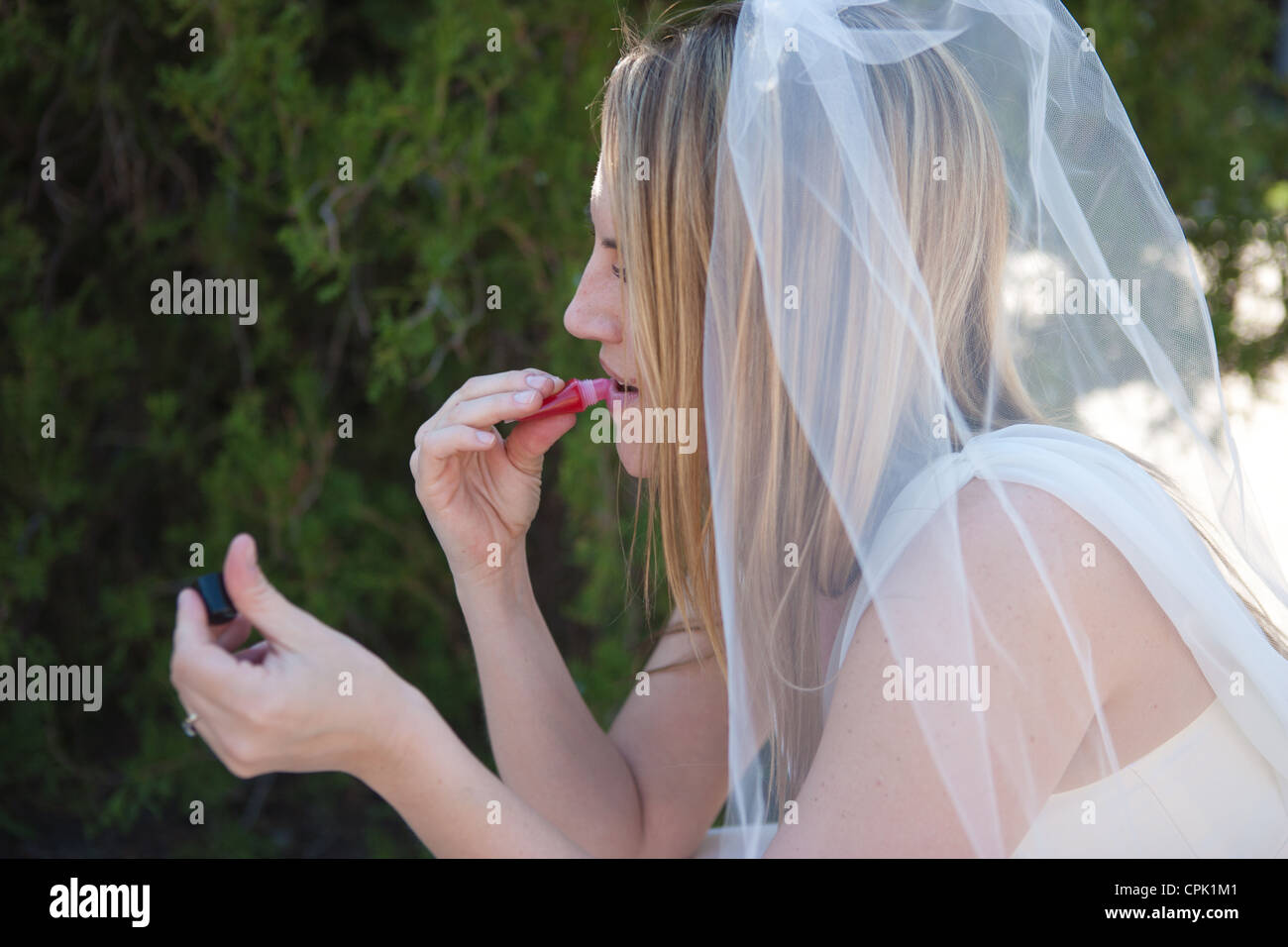 Novia poniendo en lip gloss antes de su boda. Foto de stock