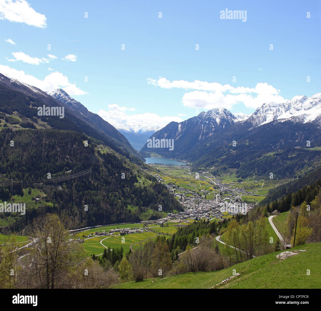 Vista de los Alpes Suizos desde el Bernina Express tren con la ciudad y el lago de Poschiavo en la distancia Foto de stock