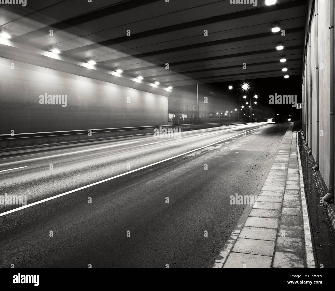 La zona de la carretera de túnel a la noche con una suave luces del coche traza. Foto de stock