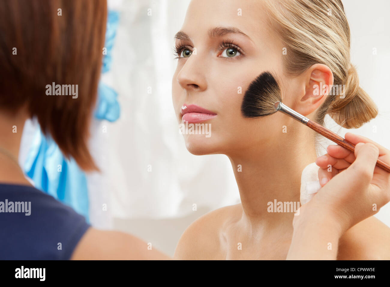 Quitar el exceso de polvo utilizando fan brush - maquillaje profesional artista trabajando Foto de stock
