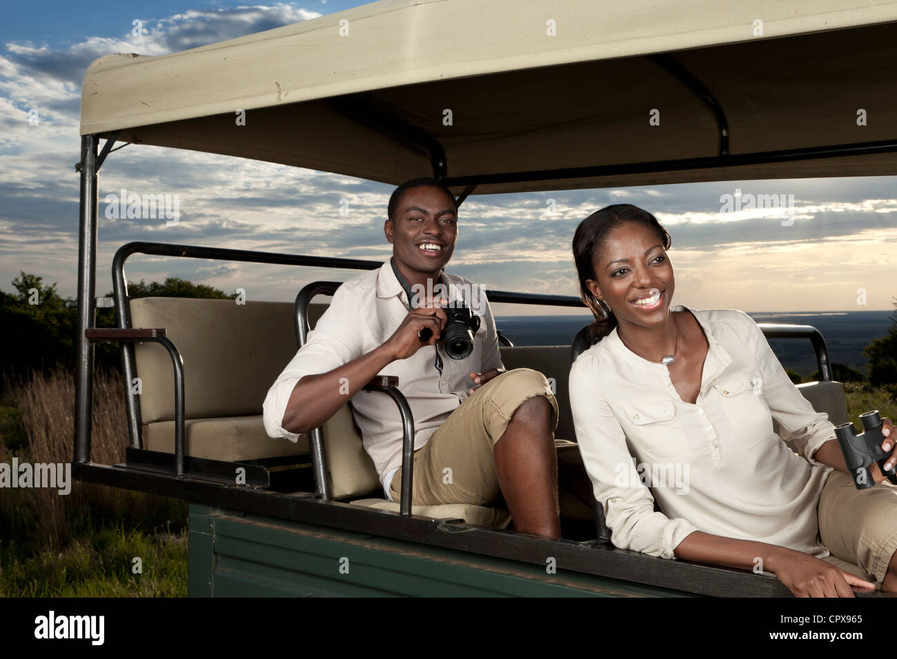 Una pareja africana sentados en un juego de visualización vehículo buscando animales Foto de stock