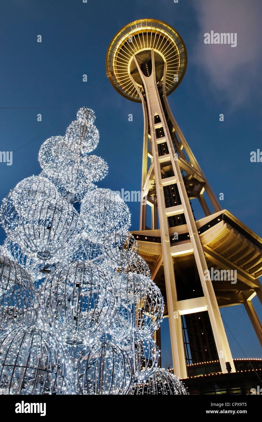Arriba vista de la Aguja Espacial de Seattle y luces de los árboles iluminados en la penumbra durante las fiestas de Navidad. Foto de stock