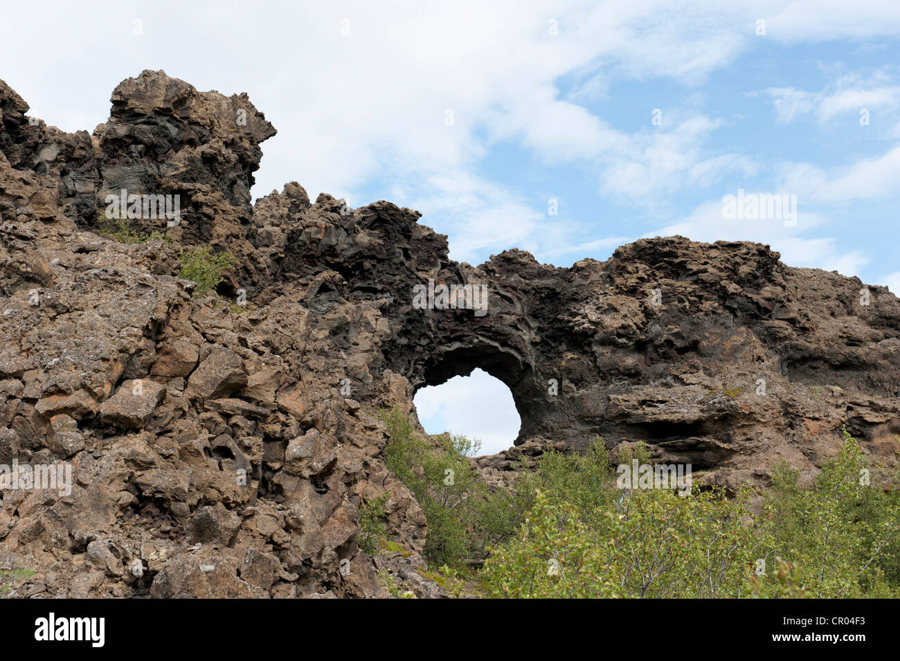 Vulcanismo, campo de lava enfriada, agujero redondo en las rocas con formas extrañas formaciones rocosas, Dimmuborgir, Lago Myvatn, la región, Myvatn Foto de stock