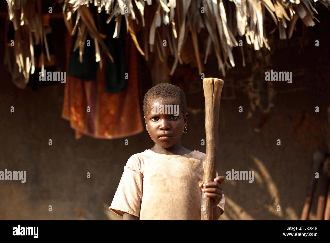 Iri Dah Clarisse, 6, toma un descanso de los ñames golpeando en la aldea de Zanzan Djorbana, región, Cote d'Ivoire Foto de stock