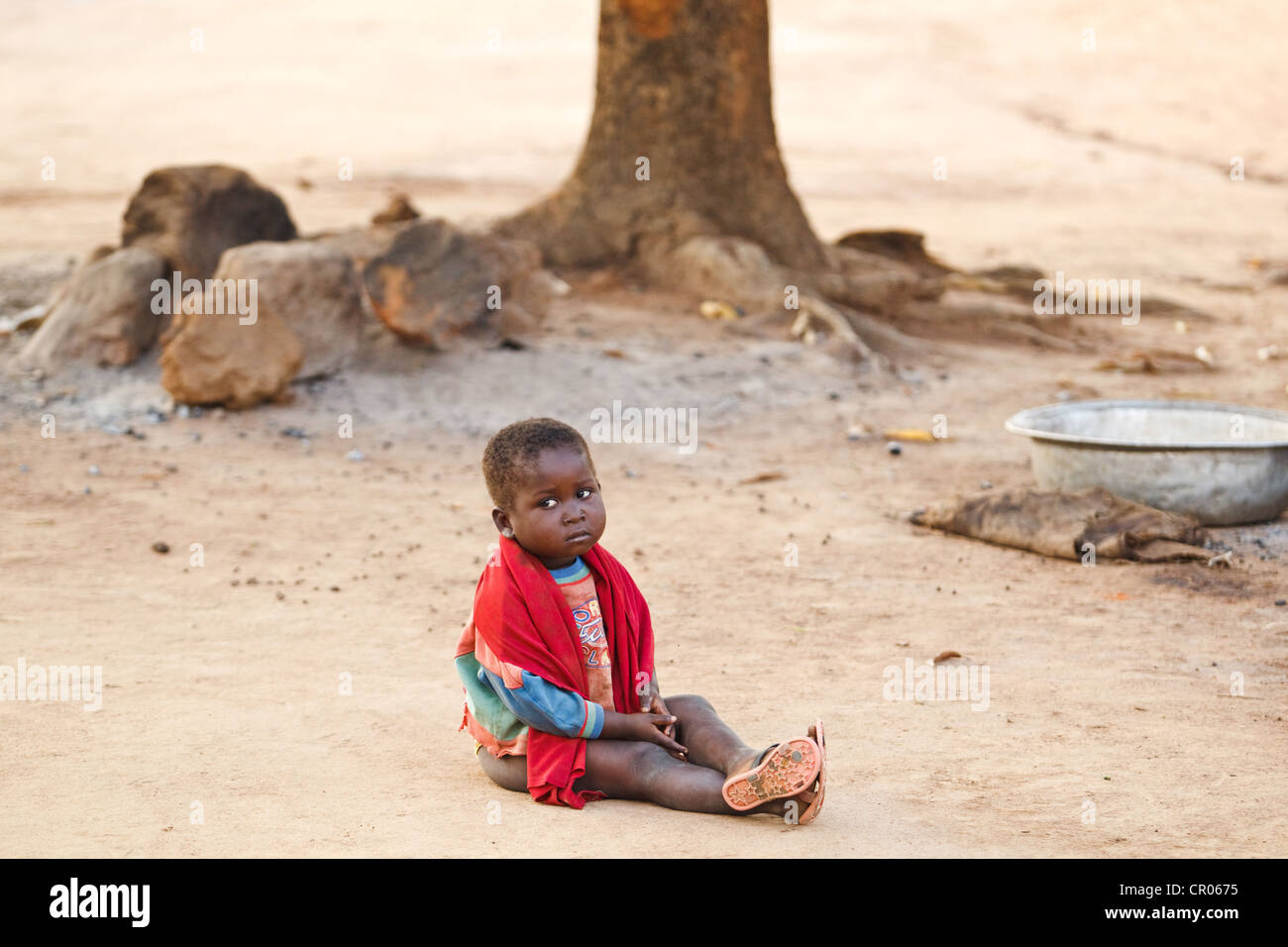 Una chica joven se sienta en el suelo en la aldea de Zanzan Djorbana, región, Cote d'Ivoire, el jueves 24 de noviembre de 2011. Foto de stock