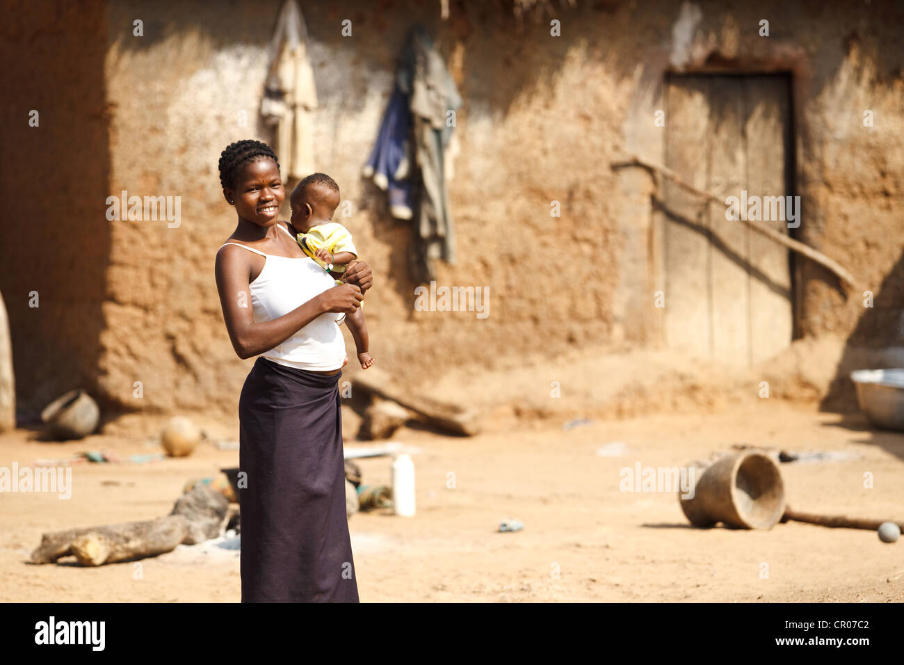 Una mujer lleva a un bebé en la aldea de Zanzan Kirkpadouo, región, Cote d'Ivoire, el sábado 26 de noviembre de 2011. Foto de stock