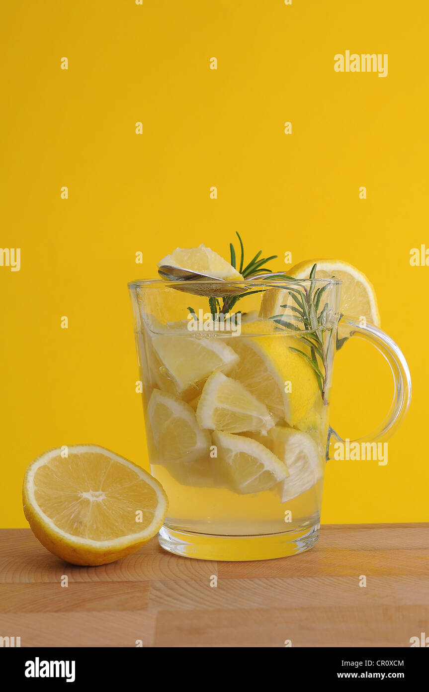 Trozos de limón, el romero, el jugo de limón, el té de limón, té glass Foto de stock