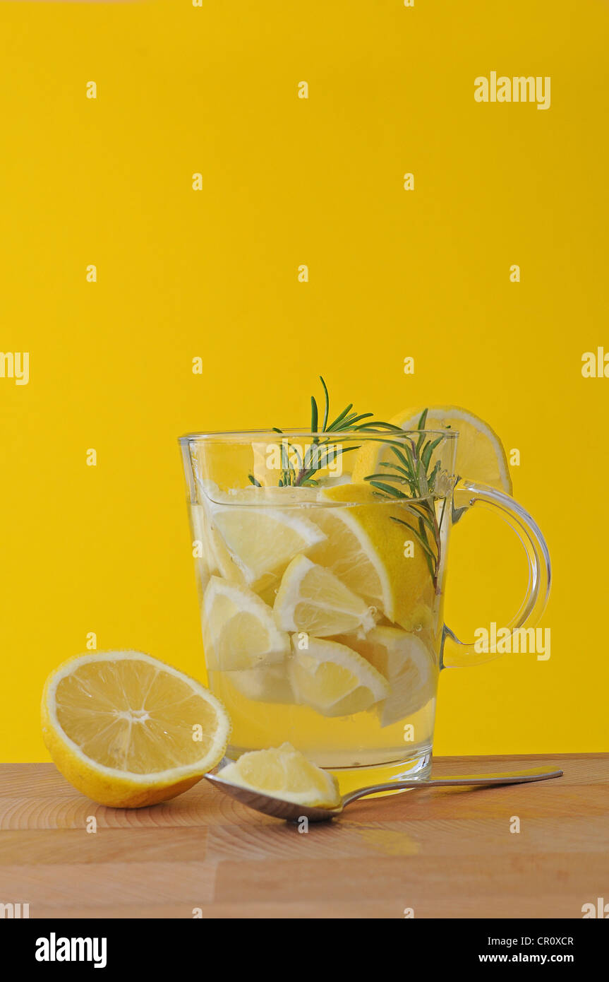 Trozos de limón, el romero, el jugo de limón, el té de limón, té glass Foto de stock