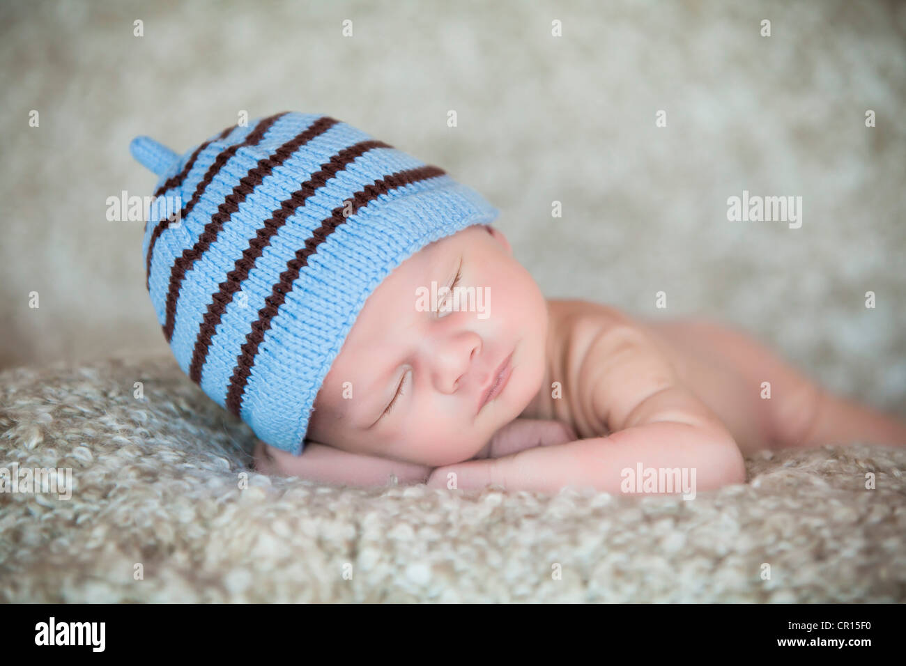 Bebé recién nacido niña vistiendo gorro blanco tejido durmiendo en