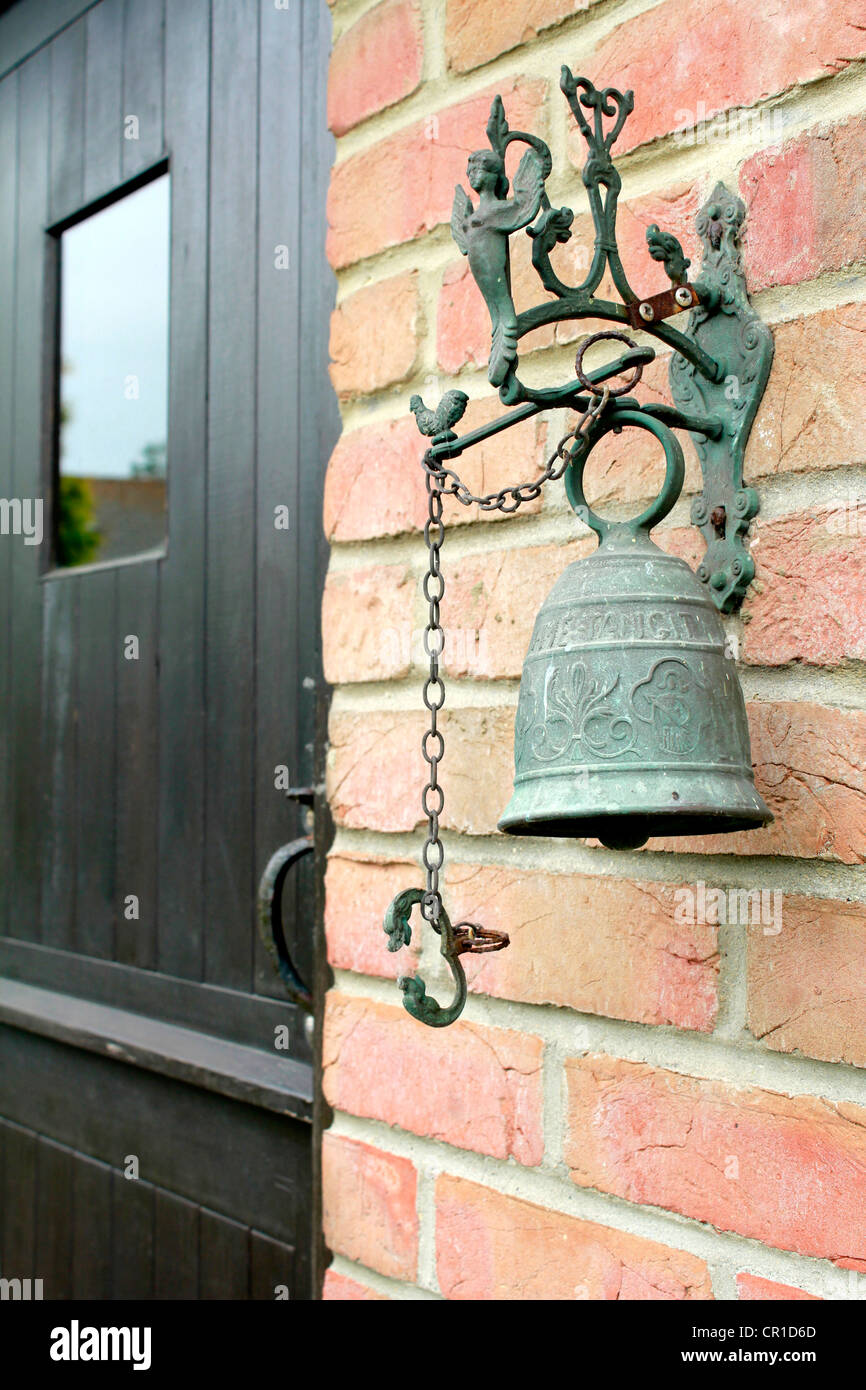 Una gran campana, junto a la puerta, reemplazando el timbre de la puerta.  la campana bienvenidos. Suena el timbre Fotografía de stock - Alamy