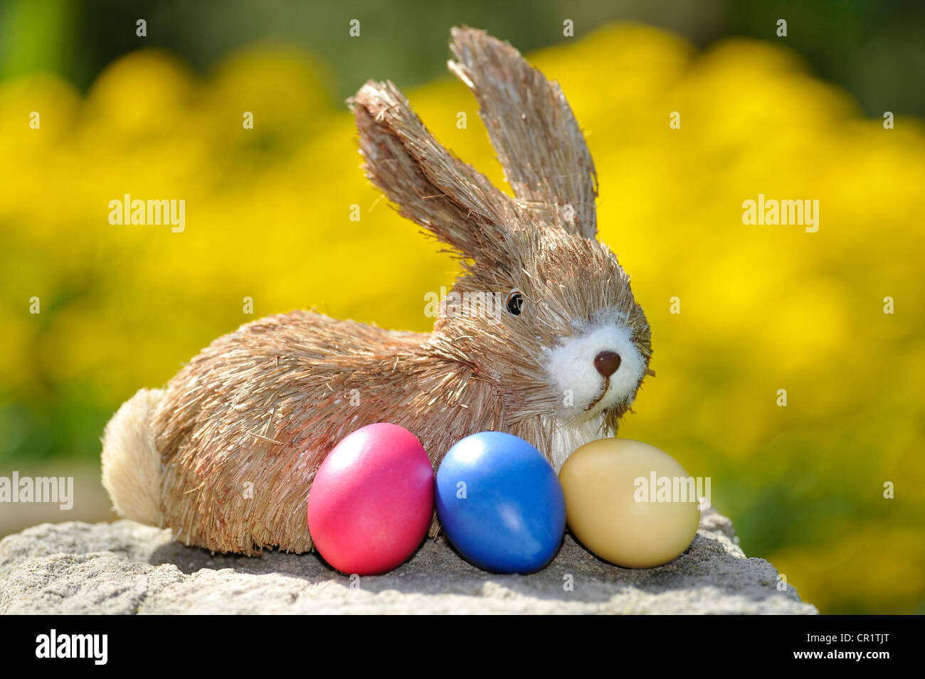 Figura conejito de Pascua con huevos de Pascua de colores brillantes Foto de stock