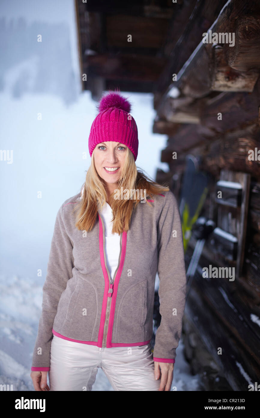 Mujer sonriente de pie en la nieve Foto de stock