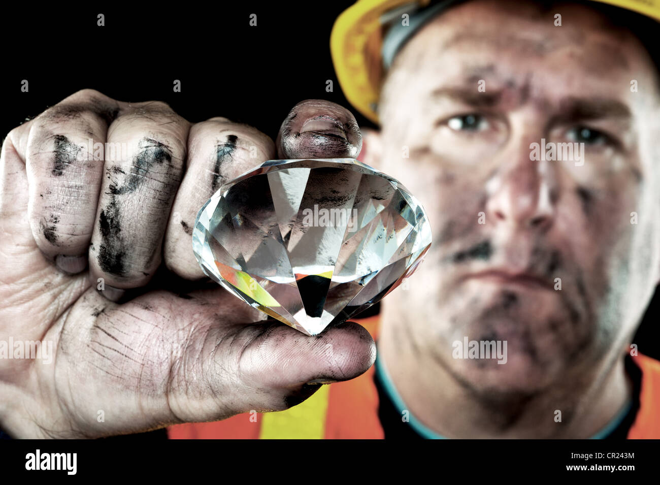 Una minera de diamantes sucios cubierta de hollín muestra una preciosa joya encontrada en una mina de carbón. Foto de stock