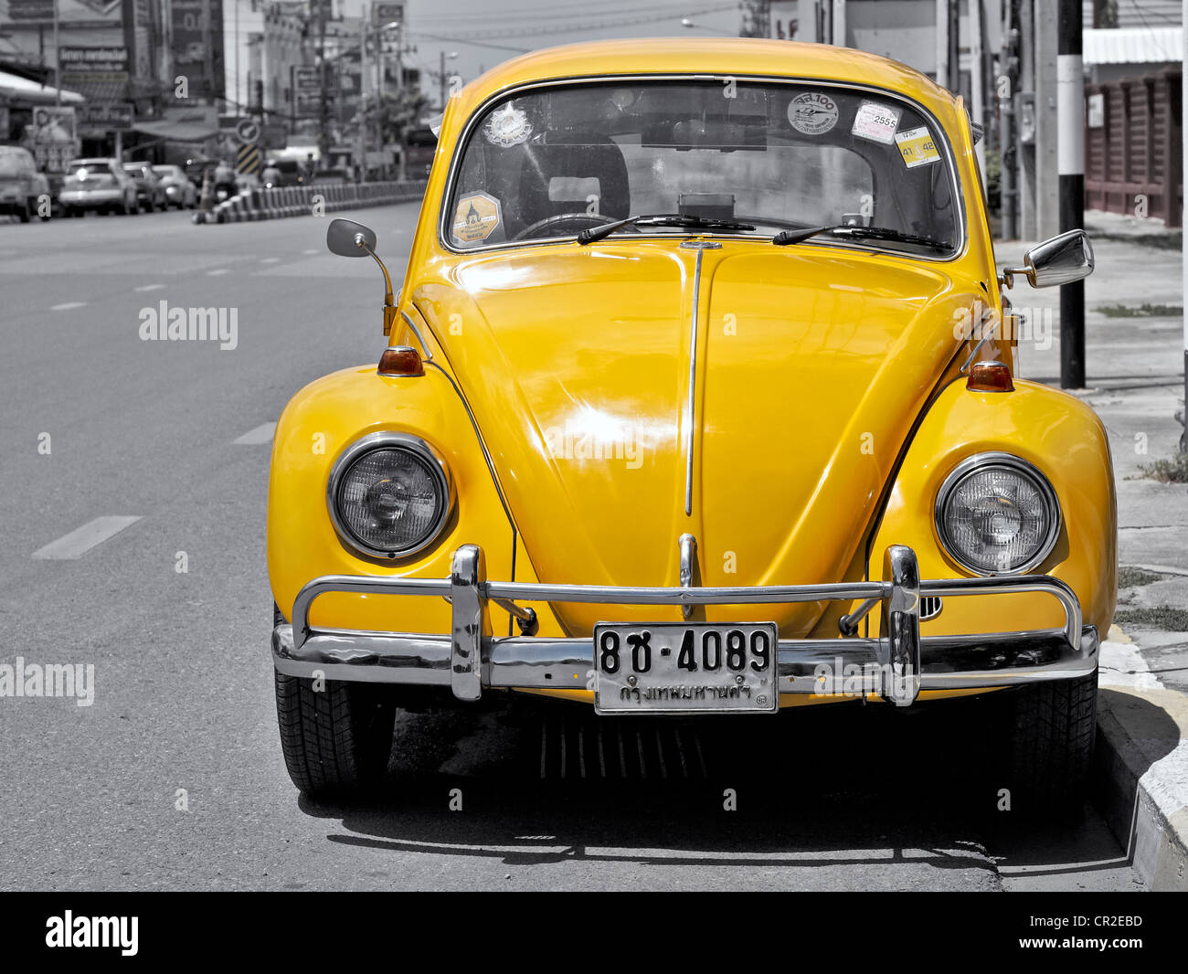 Vintage Volkswagen Beetle amarillo aparcado al lado de la carretera. Asia Tailandia Fotografía
