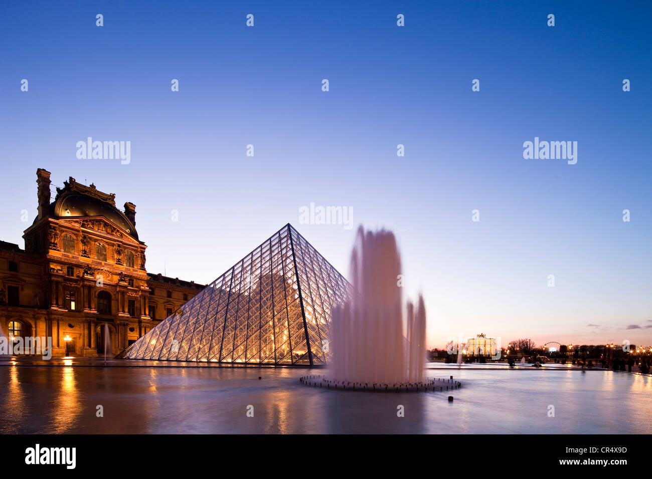 Francia, París, Museo del Louvre y la pirámide por el arquitecto Ieoh Ming Pei en la Cour Napoleón, iluminación por Claude Engle Foto de stock