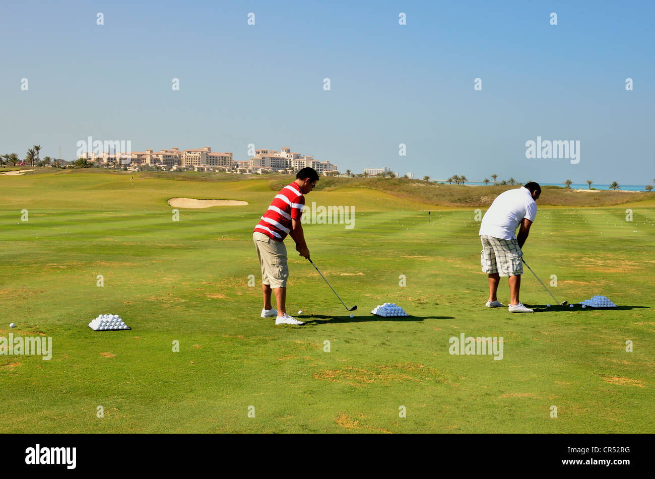 Los golfistas en el Saadiyat Beach Golf Club en la Isla de Saadiyat, Abu Dhabi, Emiratos Árabes Unidos, la Península Arábiga, Asia Foto de stock