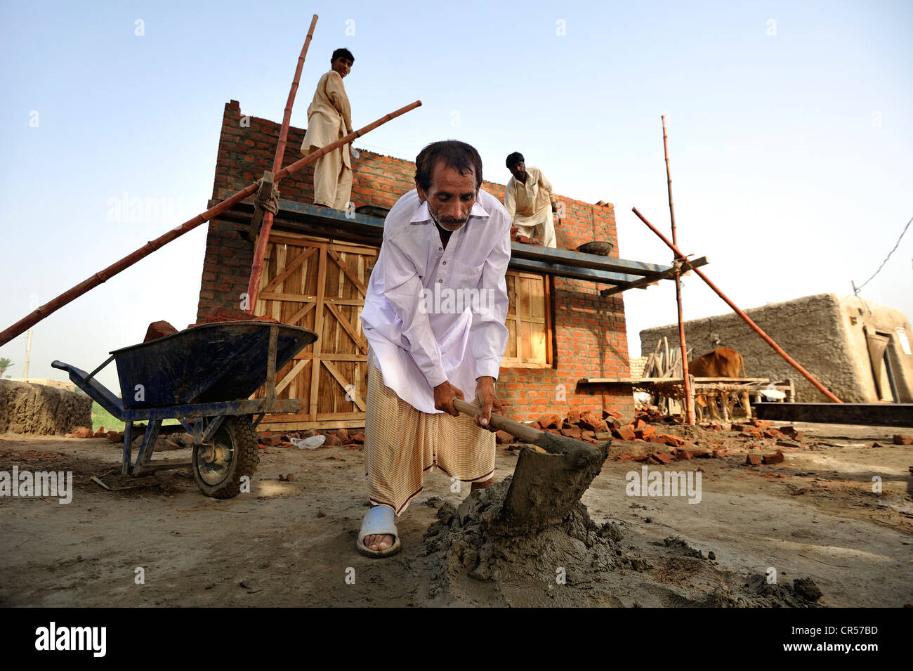 El hombre la preparación de cemento, ladrillos de construcción de casas para familias cuyas casas fueron destruidas durante la catástrofe de las inundaciones Foto de stock