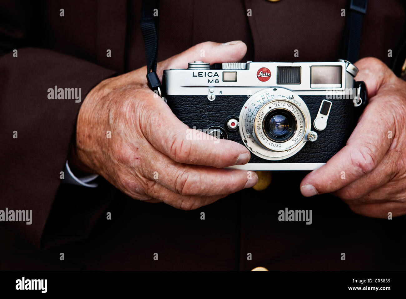 Las manos de un anciano sosteniendo una cámara Leica de telémetro, al norte del Tirol, Austria, Europa Foto de stock